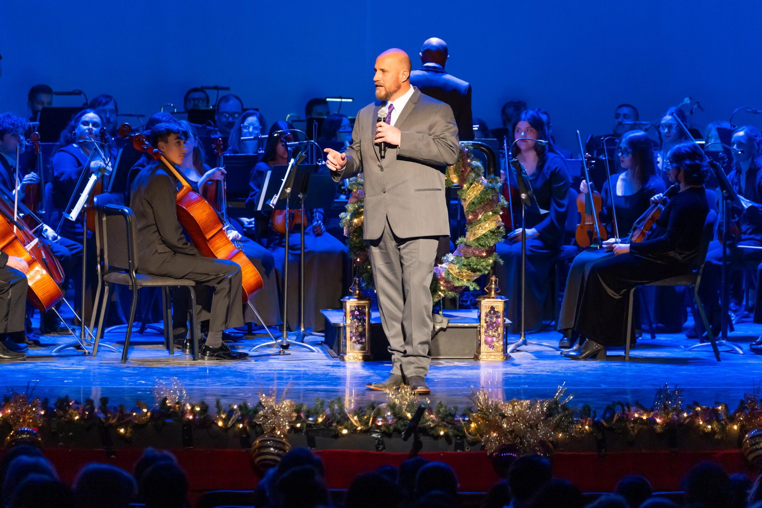 Man speaking on stage during Christmas concert